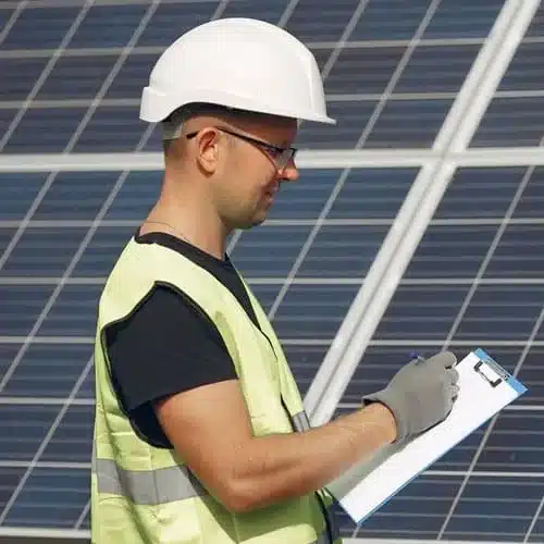 Técnico inspeccionando un sistema de paneles solares durante una revisión técnica